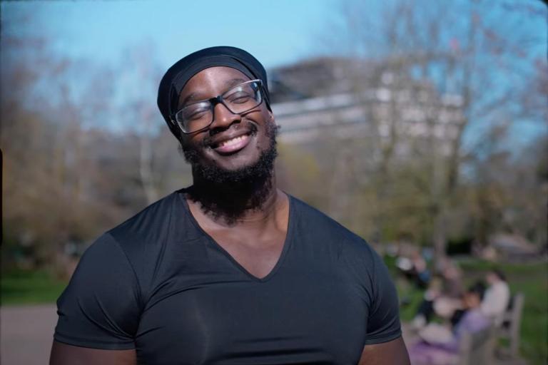 Nathan Lewis, Community Member, a black man facing the camera smiling